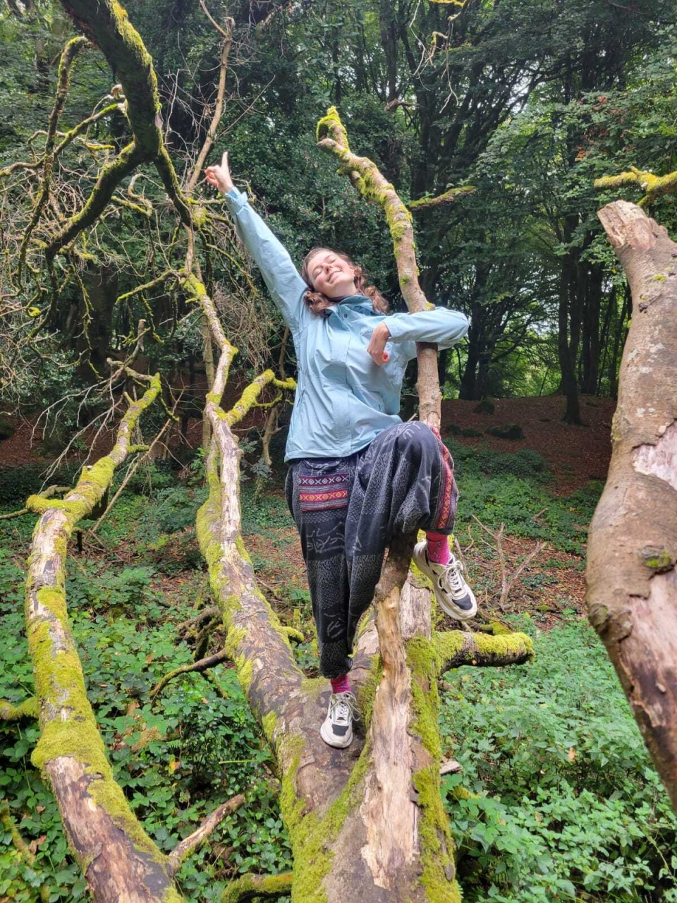 A happy Elisa out in nature on a tree.