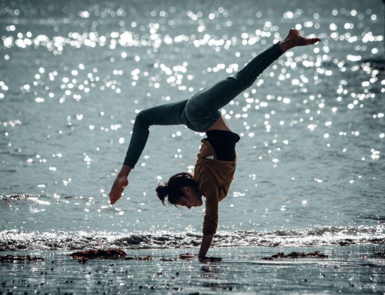 Isabela doing a handstand on the beach in Salthill